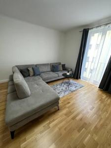 a living room with a couch and a wooden floor at Gemütliche 2- Zimmer Apartment Nähe Neu Donau in Vienna