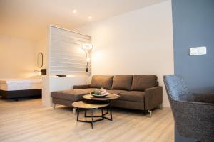 ein Wohnzimmer mit einem Sofa und einem Tisch in der Unterkunft Hotel zur Eiche in Salzkotten