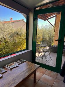 Cette chambre dispose d'une table, d'une fenêtre et d'une terrasse. dans l'établissement Halte en Provence, à Peyruis