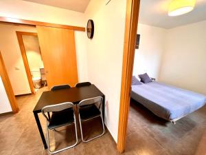 a bedroom with a bed and a table and chairs at MT Nuevos Apartamentos y Suites con baño privado in Mataró