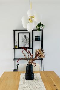 uma mesa de jantar com um vaso com flores em Haus am Bodensee mit Sicht - Stilvoller Luxus em Ermatingen