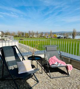 um par de cadeiras e uma mesa na varanda em Haus am Bodensee mit Sicht - Stilvoller Luxus em Ermatingen