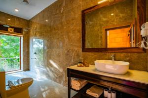 bagno con lavandino e specchio di Hotel Helsinki House a Jaisalmer