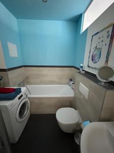 La salle de bains est pourvue d'une baignoire, de toilettes et d'un lavabo. dans l'établissement Loft mit 2 Terrassen - ruhig&sonnig, à Leipzig