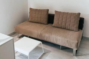 een bruine bank in een kamer met een witte tafel bij Resort Petrasia in Villammare