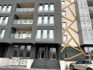 ein Gebäude mit einem davor geparkt in der Unterkunft Apartament Mihai Cassas Residence in Craiova