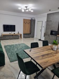 ein Wohnzimmer mit einem Holztisch und Stühlen in der Unterkunft Apartament Mihai Cassas Residence in Craiova
