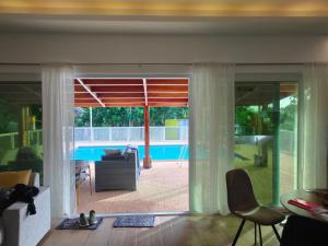 sala de estar con puerta corredera de cristal que da a la piscina en Johansen's Residence, en San Juan