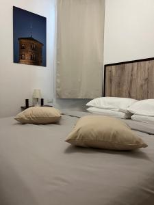 - 2 oreillers sur un lit avec un bâtiment en arrière-plan dans l'établissement Pascoli 21/A, à Ravenne