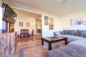 a living room with a couch and a flat screen tv at Villa Sophia in Caleta De Fuste