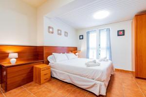 una camera da letto con un letto grande con testiera in legno di Villa Sophia a Caleta De Fuste Altre 9 foto