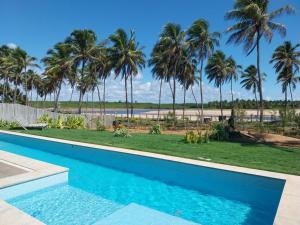 una piscina con palme e una spiaggia di Beach house - secured, beach access, sea view, best location a Baixio