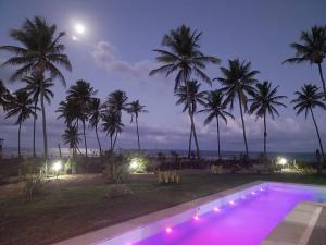 una piscina notturna con palme di Beach house - secured, beach access, sea view, best location a Baixio