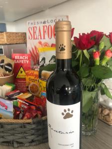 una bottiglia di vino accanto a un vaso di fiori di Ocean Drive Deluxe Apartment ground floor Brean with a complimentary Tray a Brean