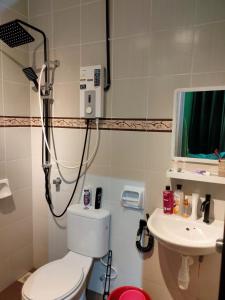 a bathroom with a shower and a toilet and a sink at Amani Homestay in Melaka