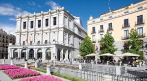 a white building with pink flowers in front of it at Bonito apartamento junto a la Plaza Mayor in Madrid