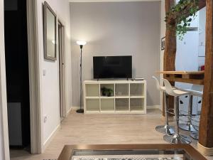 a living room with a television and a table at Bonito apartamento junto a la Plaza Mayor in Madrid