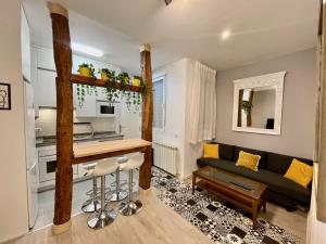 uma cozinha e sala de estar com um sofá e uma mesa em Bonito apartamento junto a la Plaza Mayor em Madri