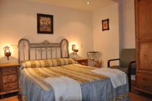 1 dormitorio con 1 cama grande y 1 silla en Apartamentos Albarcas, en Villares de Jadraque