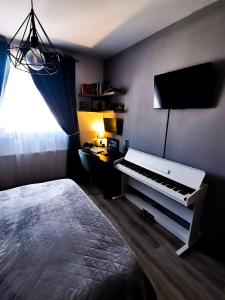 - une chambre avec un piano et une télévision murale dans l'établissement STUDIO UNO GHIMBAV, à Ghimbav