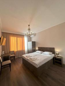 a bedroom with a bed and a table and a chair at Bina N28 in Kutaisi