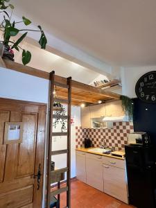 una cocina con una puerta que da a una cocina con encimera en Cosy Provençal, en Belgentier