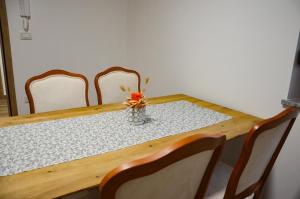 Apartmaji Tanto Malovše في Črniče: طاولة بأربعة كراسي و مزهرية عليها زهور