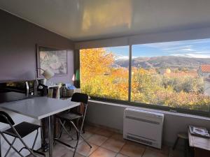 Cette chambre dispose d'une table et d'une grande fenêtre. dans l'établissement Halte en Provence, à Peyruis