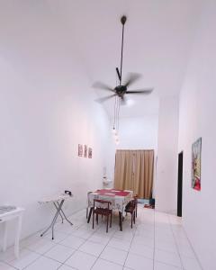 ein Esszimmer mit einem Tisch und einem Deckenventilator in der Unterkunft Aidee Homestay Taman Ria Height in Tawau