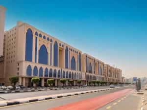 ein großes Gebäude mit blauen Fenstern auf einer Straße in der Unterkunft Alayam Elite Hotel in Mekka