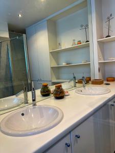 ein Badezimmer mit zwei Waschbecken und einem großen Spiegel in der Unterkunft Évasion Boisée à 2 pas des JO et de Paris in Joinville-le-Pont