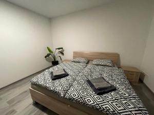 une chambre avec un lit avec une couette noire et blanche dans l'établissement Stošice Residence, à Liptovský Mikuláš