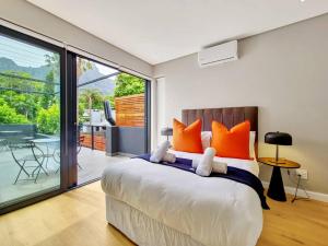 a bedroom with a large bed with orange pillows at Luxurious Family home in Newlands with Pool in Cape Town