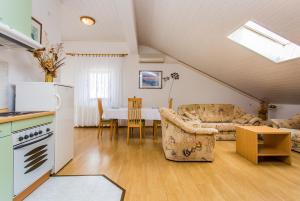 a kitchen and living room with a couch and a table at Guest house Lavanda 4 in Njivice