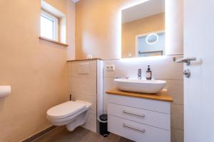 a bathroom with a sink and a toilet at Ferienhaus Zum Kuckuck, Wng 2, Urlaub im Eichsfeld in Kallmerode +32 photos