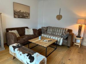 a living room with two couches and a coffee table at Chalet Bergglück in Piesendorf