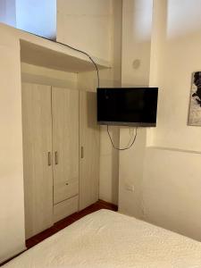 Apartamento Familiar Puerta Azul في مومبوس: غرفة نوم مع سرير وتلفزيون على الحائط