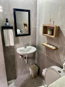 y baño con lavabo, aseo y espejo. en Apartamento Familiar Puerta Azul, en Mompox