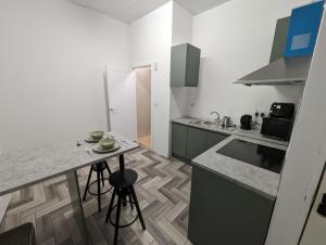 a kitchen with a counter and a table with stools at Stylish Studio Apt at the Rock Bury in Bury