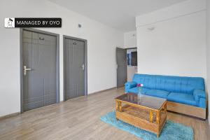 a living room with a blue couch and a coffee table at Super Townhouse HAL Indiranagar Extension in Bangalore
