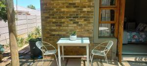 a white table and two chairs on a patio at Coco's Hamlet Self Catering Accommodation in Prince Alfreds Hamlet