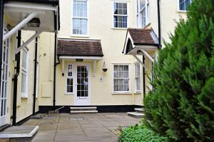 a yellow house with a white door and windows at Cosy Studio - Private Entrance Bishop’s Stortford in Bishops Stortford