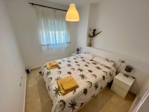 a small bedroom with a bed and a window at Apartamento Pinares del Portil a pie de playa in El Portil