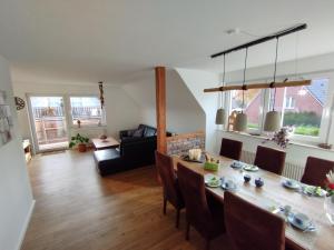 a dining room and living room with a table and chairs at Ferienwohnung Schmidt in Schüttorf +12 photos