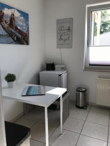 una mesa blanca en una habitación con nevera en FeWo Malum, Sonniges Apartment direkt an der Ostsee, en Zierow