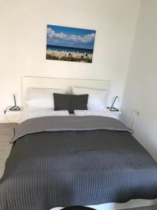 a bedroom with a bed with a picture on the wall at FeWo Malum, Sonniges Apartment direkt an der Ostsee in Zierow