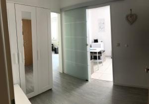 Habitación de planta abierta con pasillo con mesa y espejo. en FeWo Malum, Sonniges Apartment direkt an der Ostsee, en Zierow