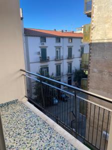 einen Balkon mit Blick auf ein weißes Gebäude mit einem Zaun in der Unterkunft La reggia di Gianna in Caserta