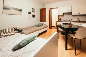 eine Küche und ein Wohnzimmer mit einem Bett und einem Tisch in der Unterkunft Appartamento Castelli - Affitti Brevi Italia in Varese
