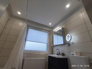 een badkamer met een raam, een wastafel en een spiegel bij Apartment Feldkirch in Feldkirch